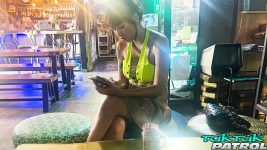 Pattaya bargirl uses her phone while at bar