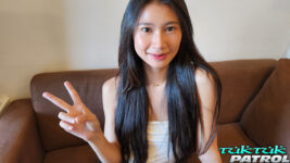 Pretty Asian babe throws up the peace sign