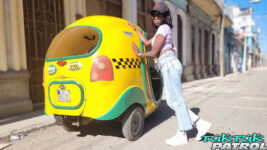 Ebony model poses next to Cuban tuktuk
